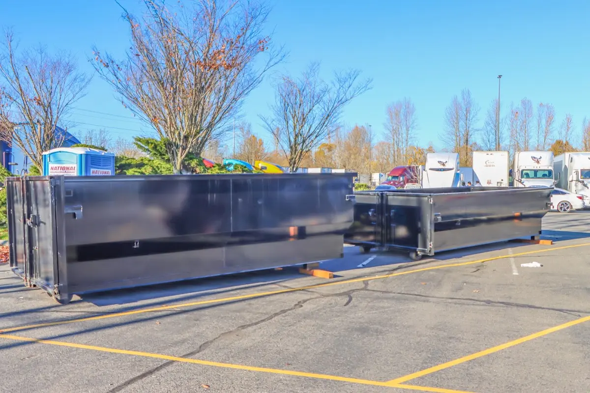 Professional dumpster rental service with roll-off container on residential driveway in Whitefish